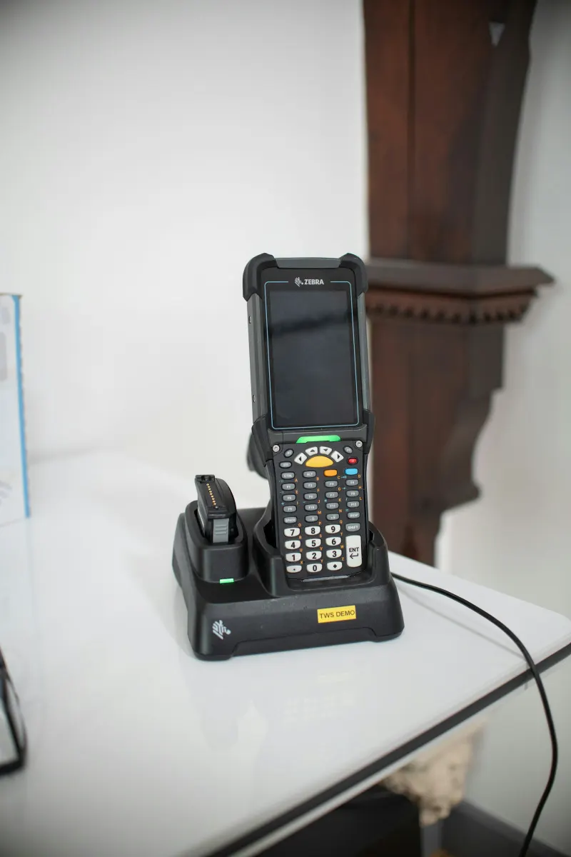Rugged handheld mobile computer with barcode scanner in its charging dock